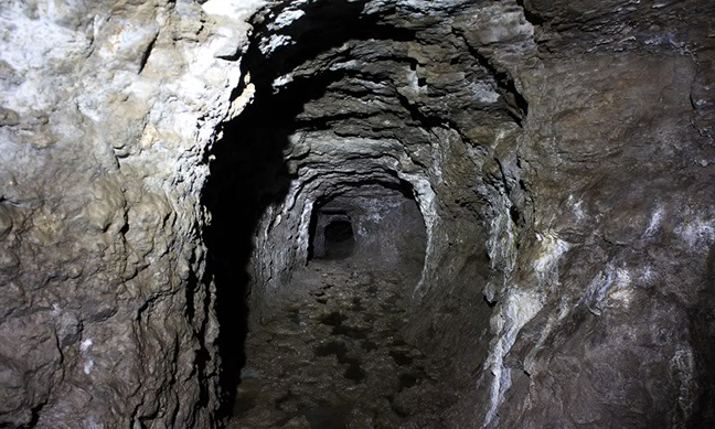 a 6' tall tunnel excavated into the dark earth.jpg